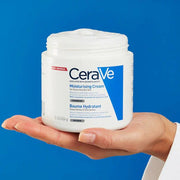 CeraVe moisturizing cream jar held in a hand against a blue background